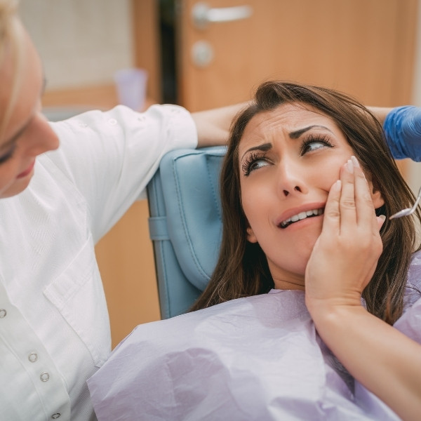 Donna con dolore ai denti e alla cervicale